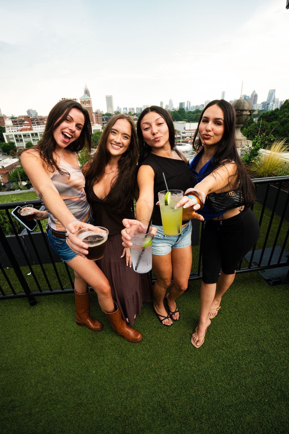 Friends raising drinks with the skyline behind them