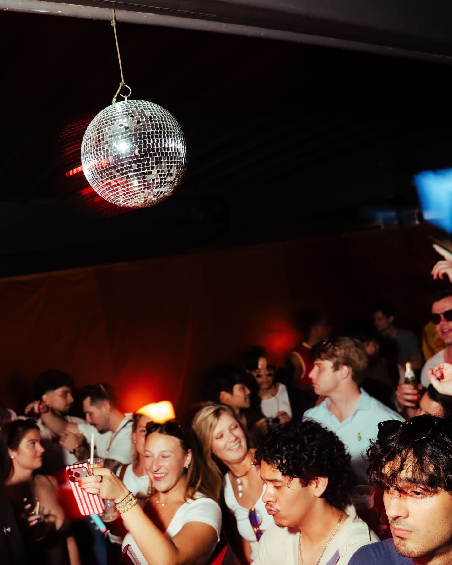 A disco ball hanging over a packed crowd