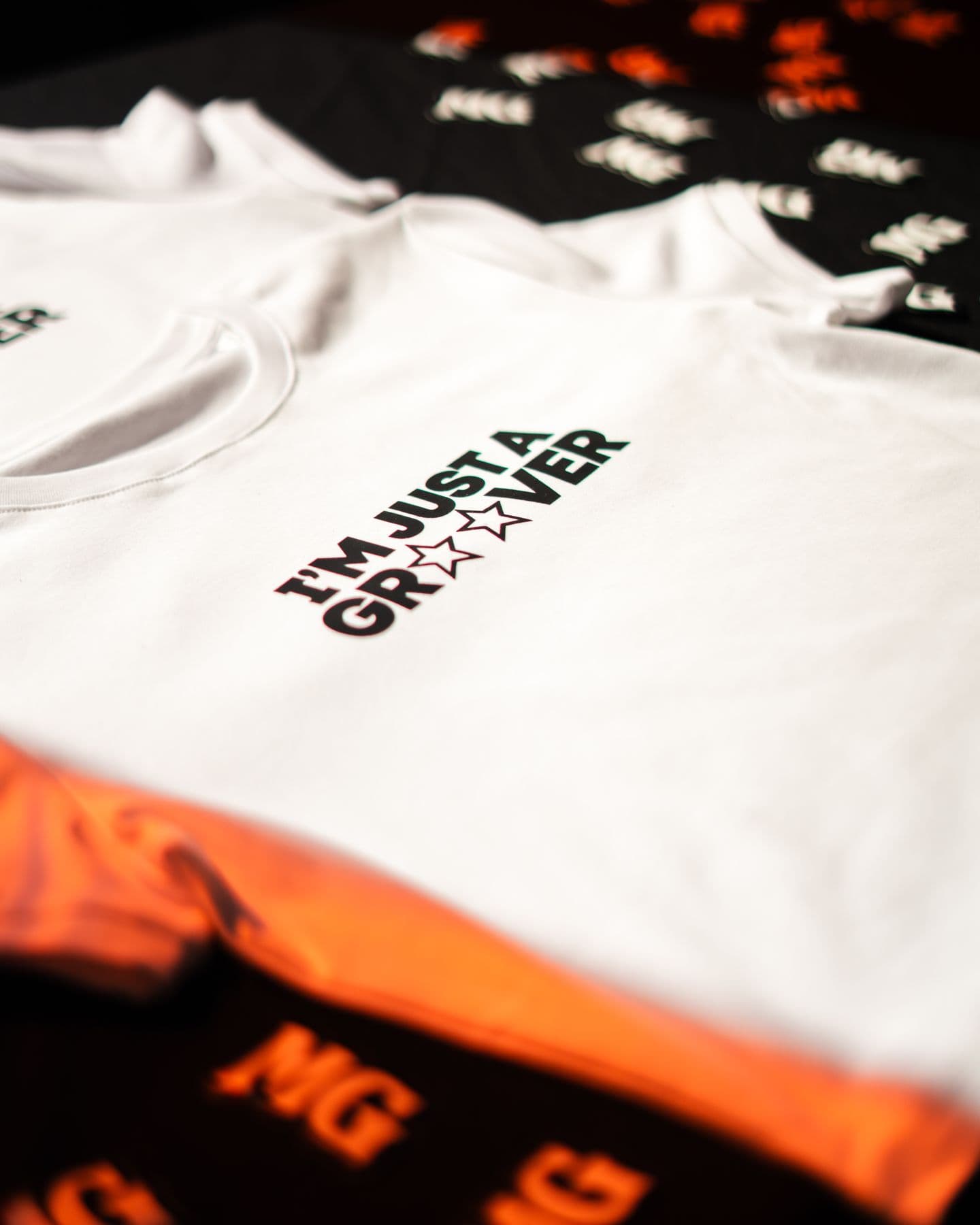 White I'm Just a Groover tees laid out on the merch table